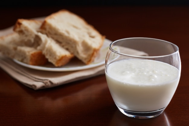 Coupe en verre avec du kéfir sur une table sombre