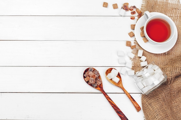 Coupe en verre de thé chaud avec du sucre sur la table