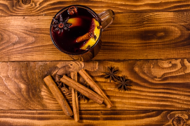 Coupe de vin chaud à la cannelle sur table en bois rustique. Vue de dessus