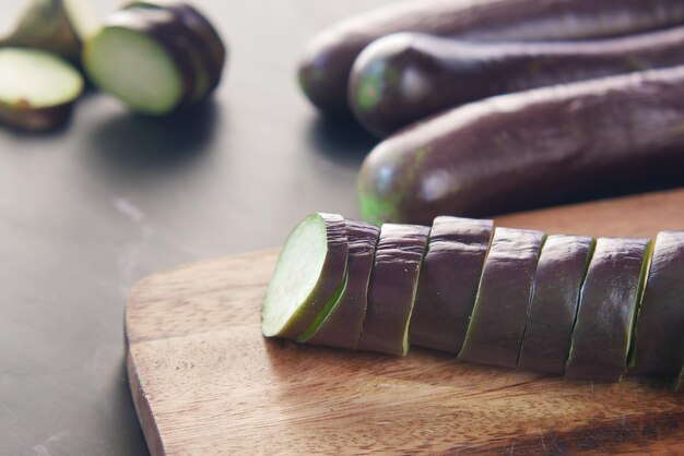 couper des aubergines sur une planche à découper