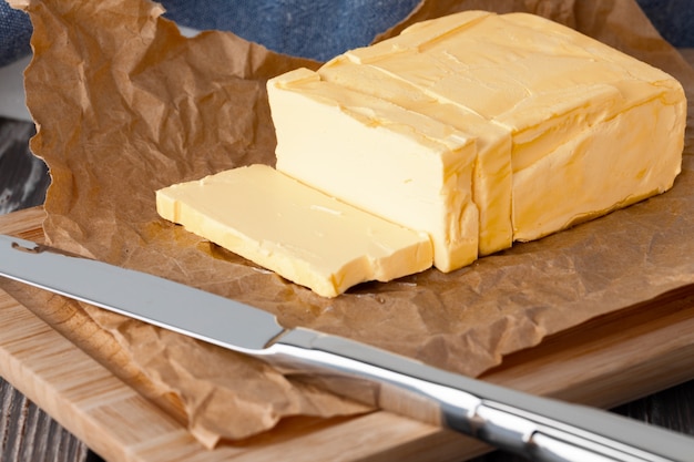 Couper le beurre sur une assiette avec une serviette bleue sur la table de la cuisine