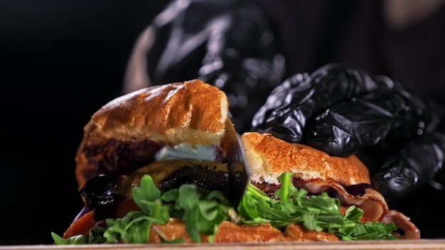 Couper le burger artisanal fait cuire sur fond noir Sauce composée