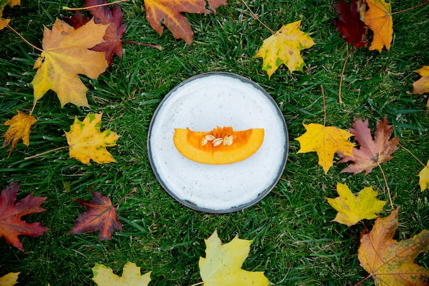 Couper la citrouille sur une assiette sur l'herbe verte