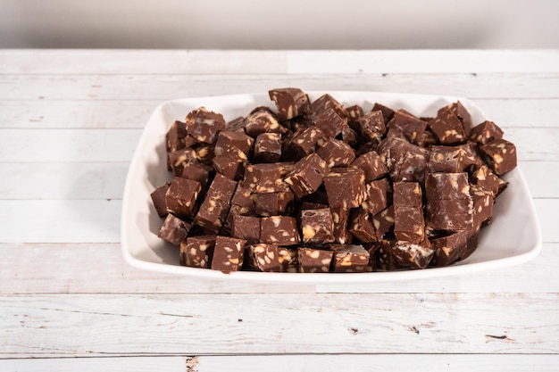 Couper le fudge aux noix de macadamia en petits cubes.