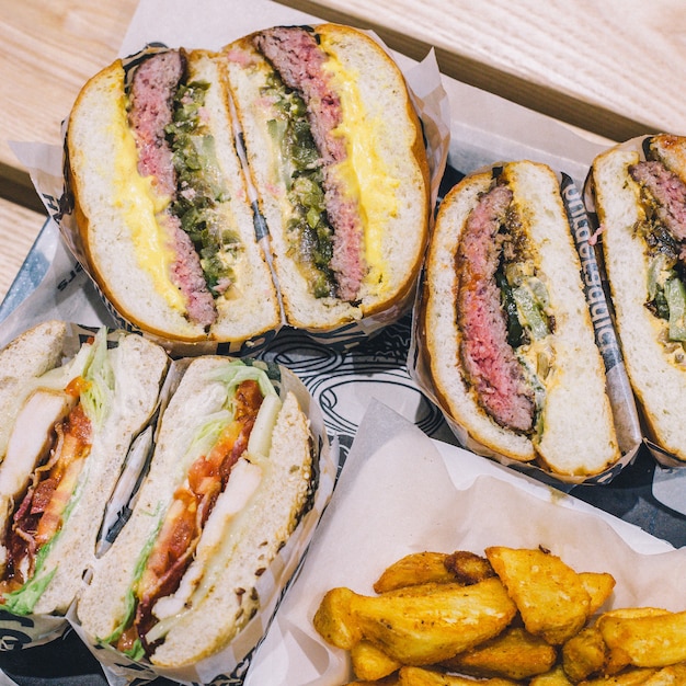 Photo couper des hamburgers à la viande et des frites sur un plateau dans un café