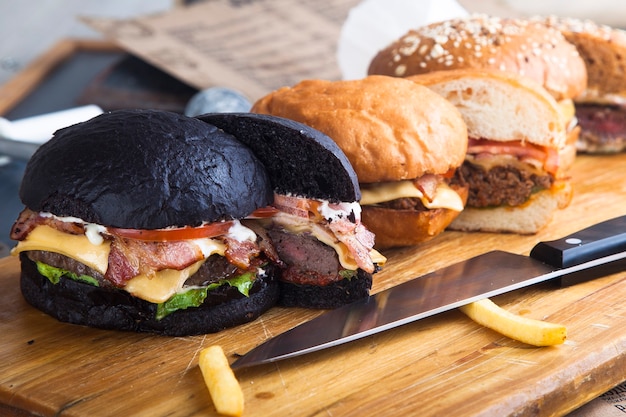 Couper des hamburgers avec de la viande sur une planche en bois avec un couteau