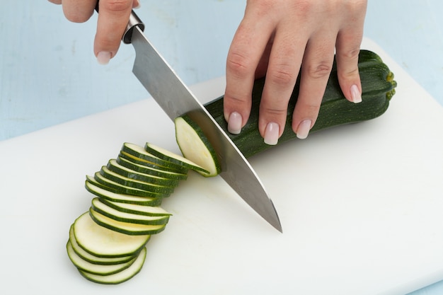 Couper les légumes avec un couteau de cuisine sur la planche