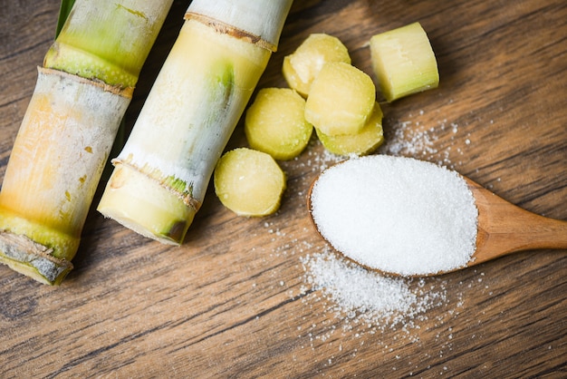 Couper le morceau de canne à sucre et le sucre blanc sur une cuillère en bois