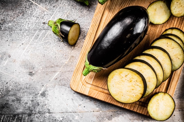 Couper en morceaux d'aubergines mûres sur une planche à découper en bois