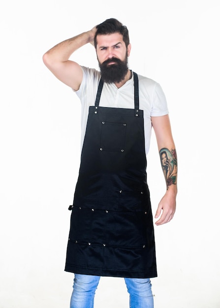 Photo couper ou ne pas couper coiffeur homme touchant les cheveux de la tête homme barbu portant un tablier de coiffeur hipster en tablier de travail avec plusieurs poches coiffeur dans un salon de coiffure barbershop ou salon de coiffure