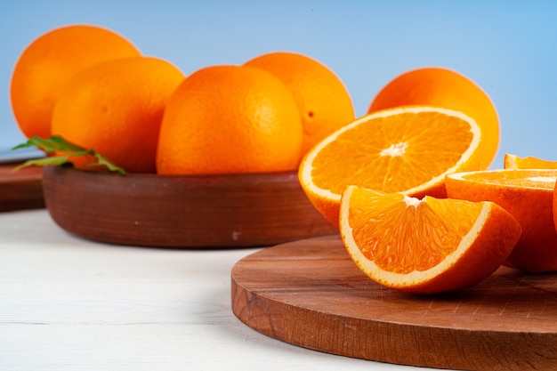 Couper les oranges sur une planche de bois sur la table