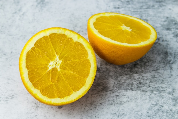 Couper des oranges sur une table lumineuse en béton