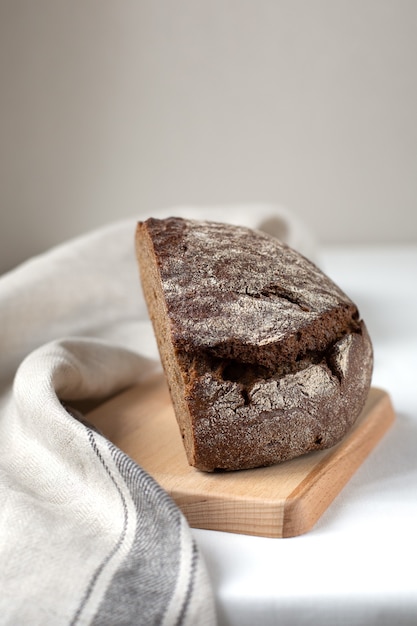 Couper le pain de seigle noir sur une planche de bois