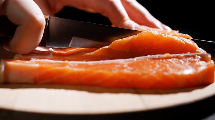 Photo couper le poisson en tranches pour la cuisson des sushis