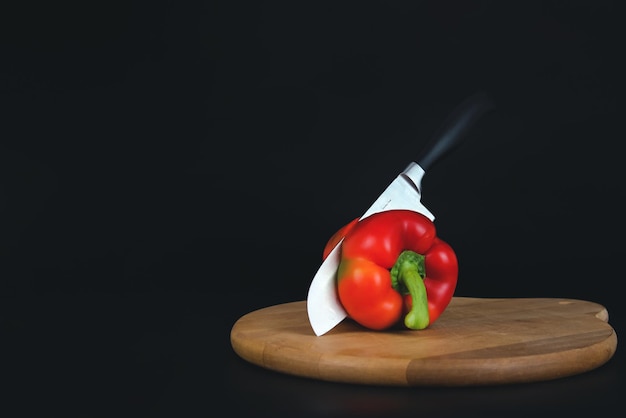 Couper le poivron rouge avec un couteau de cuisine sur le plateau