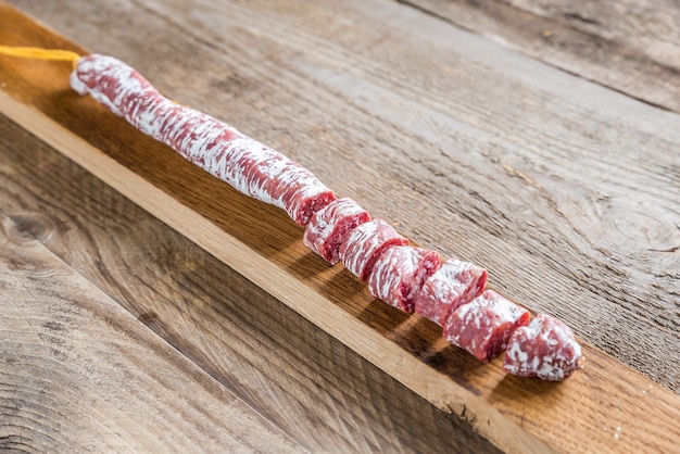 Couper le salami espagnol sur la planche de bois