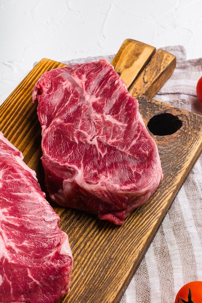 Couper la viande de boeuf de la lame supérieure de l'épaule sur fond de table en pierre blanche