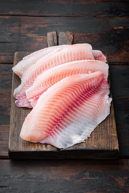 Coupes de filet de poisson blanc cru, sur la vieille table en bois