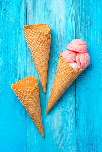 Coupes de glace et de gaufre de baie et de crème sur un fond bleu