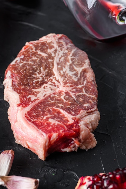 Coupes de steak de boeuf en fer plat, aux herbes, assaisonnement sur tableau noir, vue latérale.
