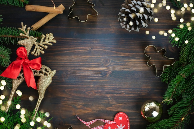 Coupeur de biscuit de cerf de Noël d'or et ornements de Noël sur le fond en bois rustique