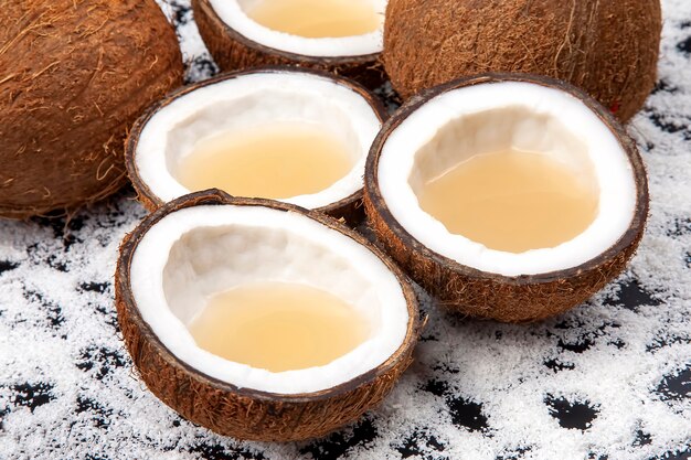 Coupez la noix de coco fraîche avec du vrai lait de coco sur une table noire de flocons de noix de coco.