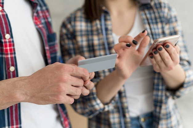 Couple achetant en ligne avec carte de crédit et téléphone