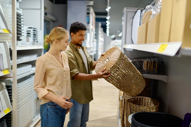 Couple achetant un panier à linge en osier au magasin