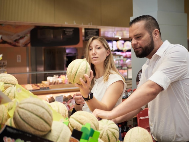 Un couple achète des fruits au supermarché