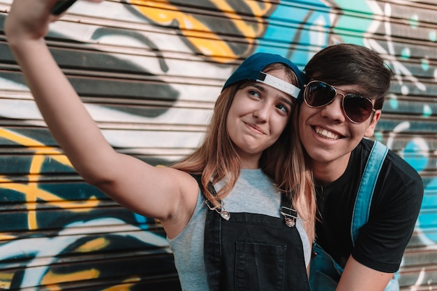 Couple d'adolescents cool prenant un selfie