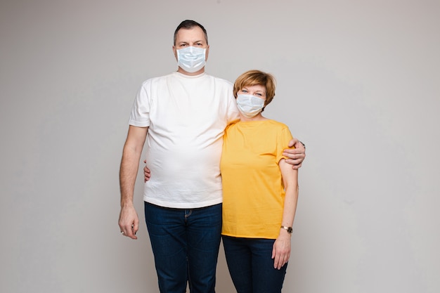 Couple adulte en masques s'embrassant