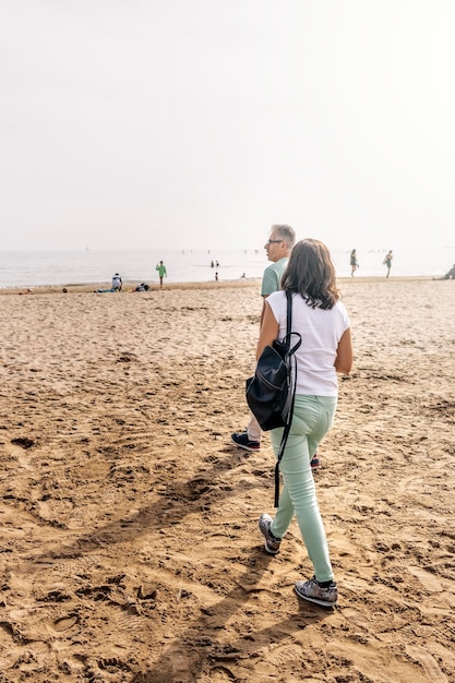 Couple adulte se promenant le long de la plage aux beaux jours