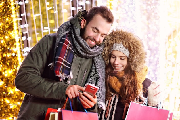 couple d'adultes faisant du shopping dans la ville pendant la période de Noël