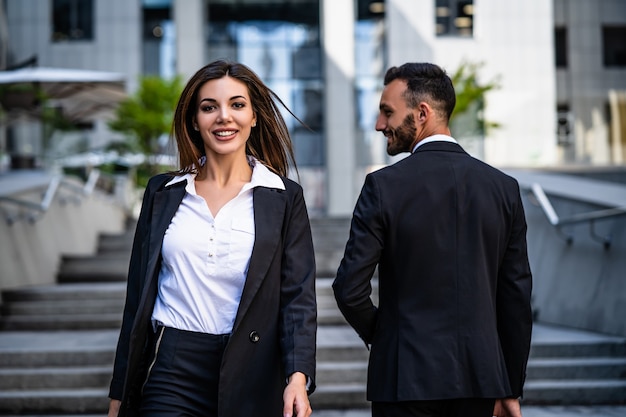 Le couple d'affaires attrayant marchant dans la ville