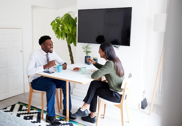 Couple d'affaires à la maison en train de prendre son petit déjeuner avant de partir travailler