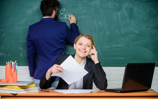 Un couple d'affaires utilise un ordinateur portable et des documents papier travail vie de bureau enseignant et étudiant en examen retour à l'école homme d'affaires de l'éducation formelle et secrétaire heureux Formulaire de demande Perdu dans ses pensées