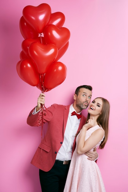 Couple affectueux avec des ballons en forme de coeur flirtant