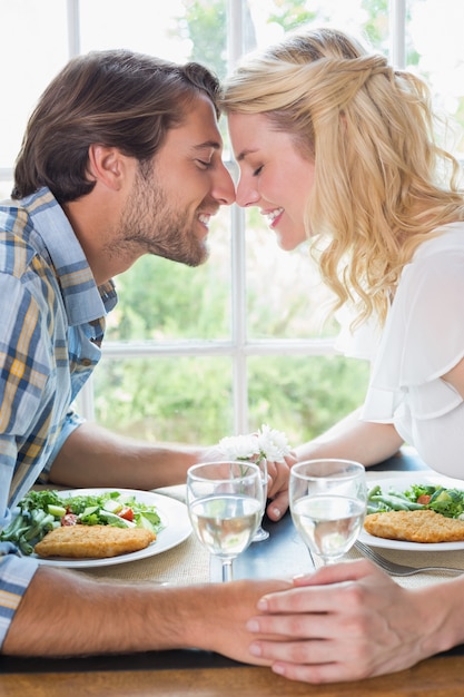 Couple affectueux mignon ayant un repas ensemble