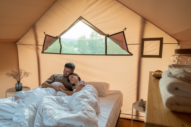 Couple affectueux regardant le paysage autour de leur tente de glamping