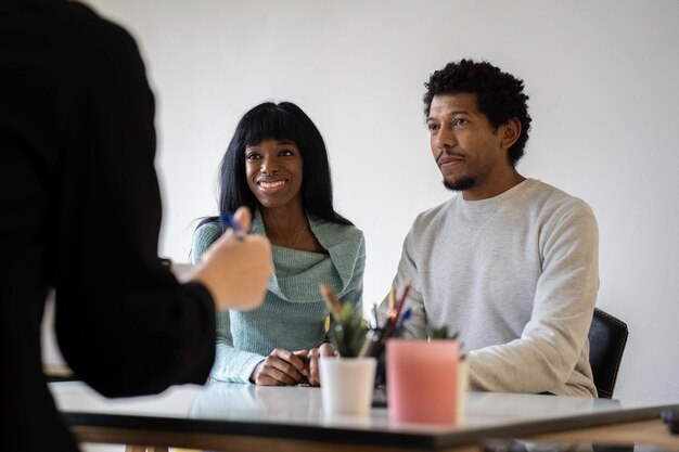 Couple afro-américain assis au bureau d'un psychologue pour une thérapie de couple Concept de relation de couple en difficulté et en crise Se concentrer sur le visage de la femme