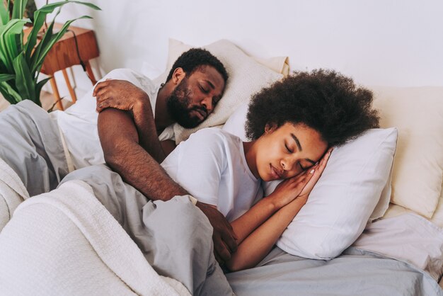 Couple afro-américain au lit Véritable belle et joyeuse paire d'amoureux à la maison