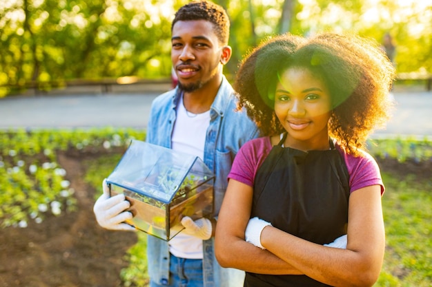 Couple afro-américain jardinage à l'extérieur au coucher du soleil journée de printemps ensoleillée