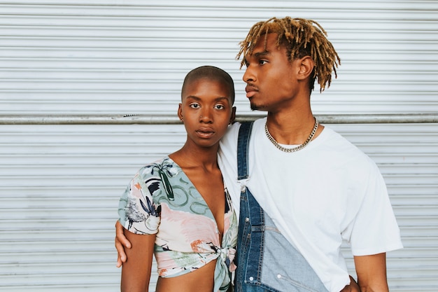 Couple afro-américain posant devant un mur