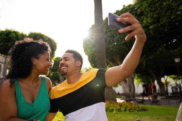 Couple afro-américain prenant une photo avec le mobile