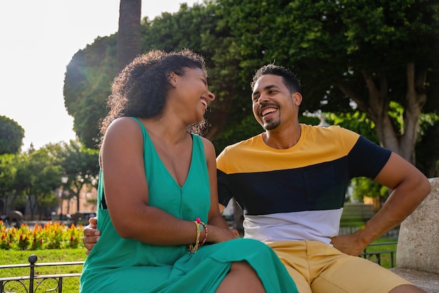 Couple afro-américain romantique assis sur un banc