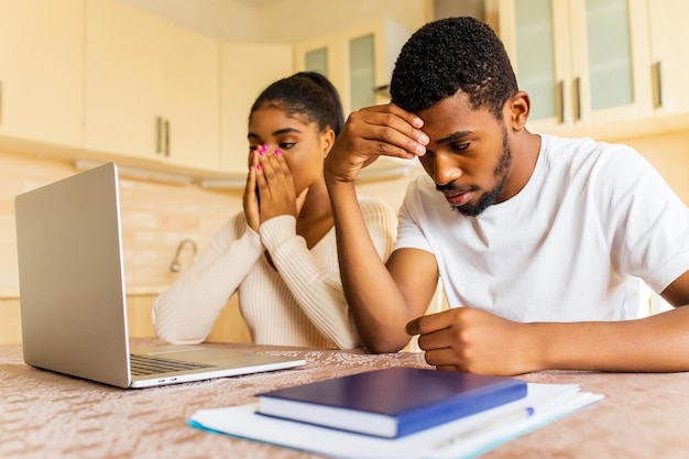 Un couple afro-américain stressé qui a l'air frustré après avoir reçu une mauvaise nouvelle de sa famille