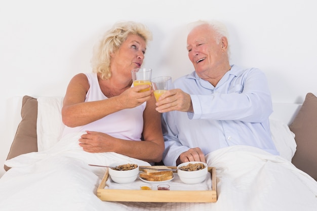 Couple âgé grillage avec du jus d&#39;orange