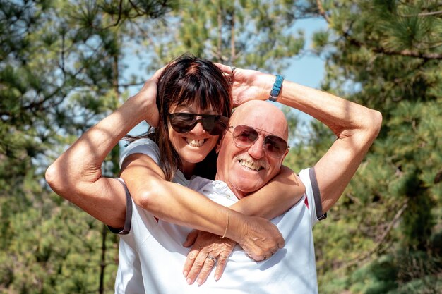 Un couple âgé joyeux s'embrasse lors d'une excursion en montagne exprimant bonheur et bien-être