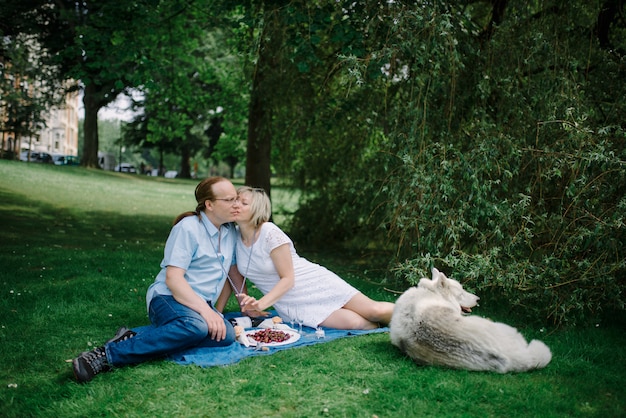 Couple d'âge moyen avec leur animal de compagnie au pique-nique