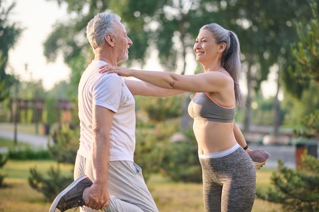 Un couple d'âge moyen s'étirant avant l'entraînement du matin